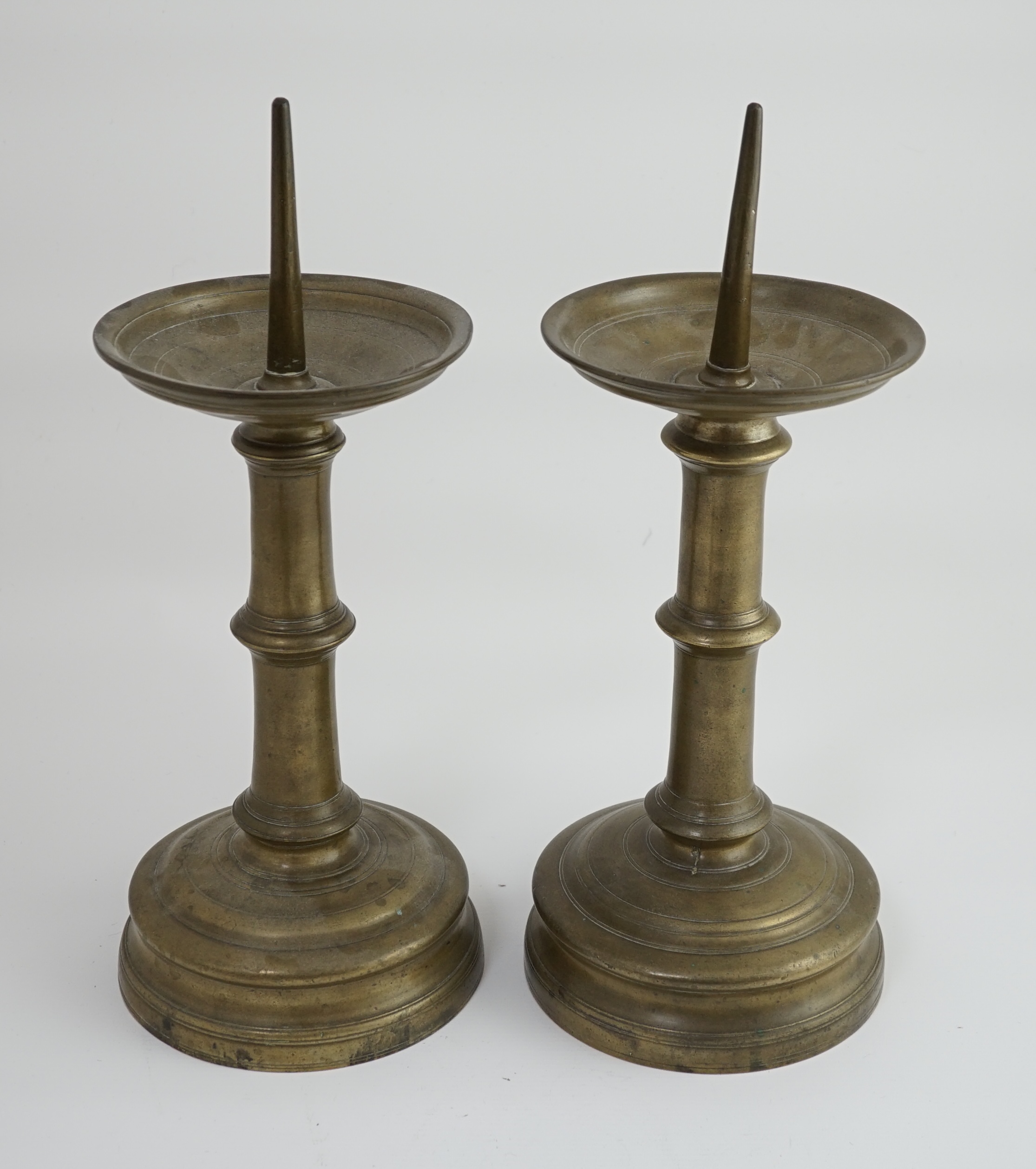 A pair of 16th century bell metal pricket candlesticks